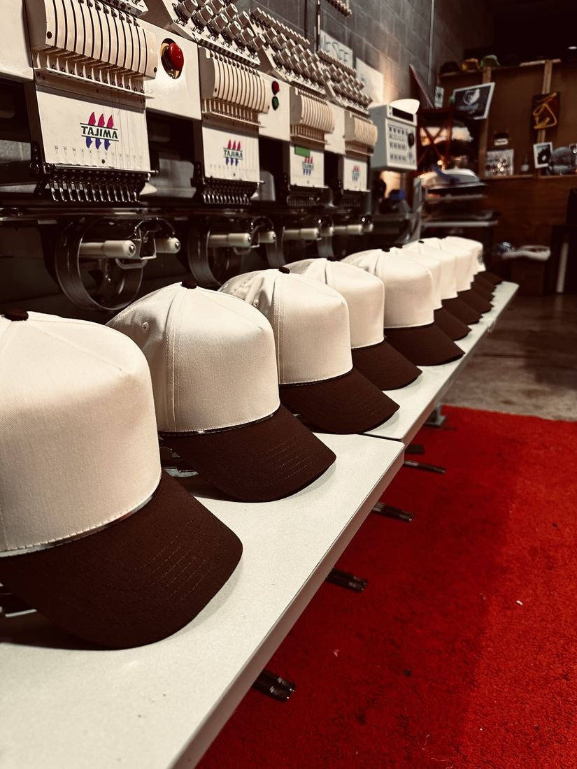 A run of two-tone hats on the embroidery machines