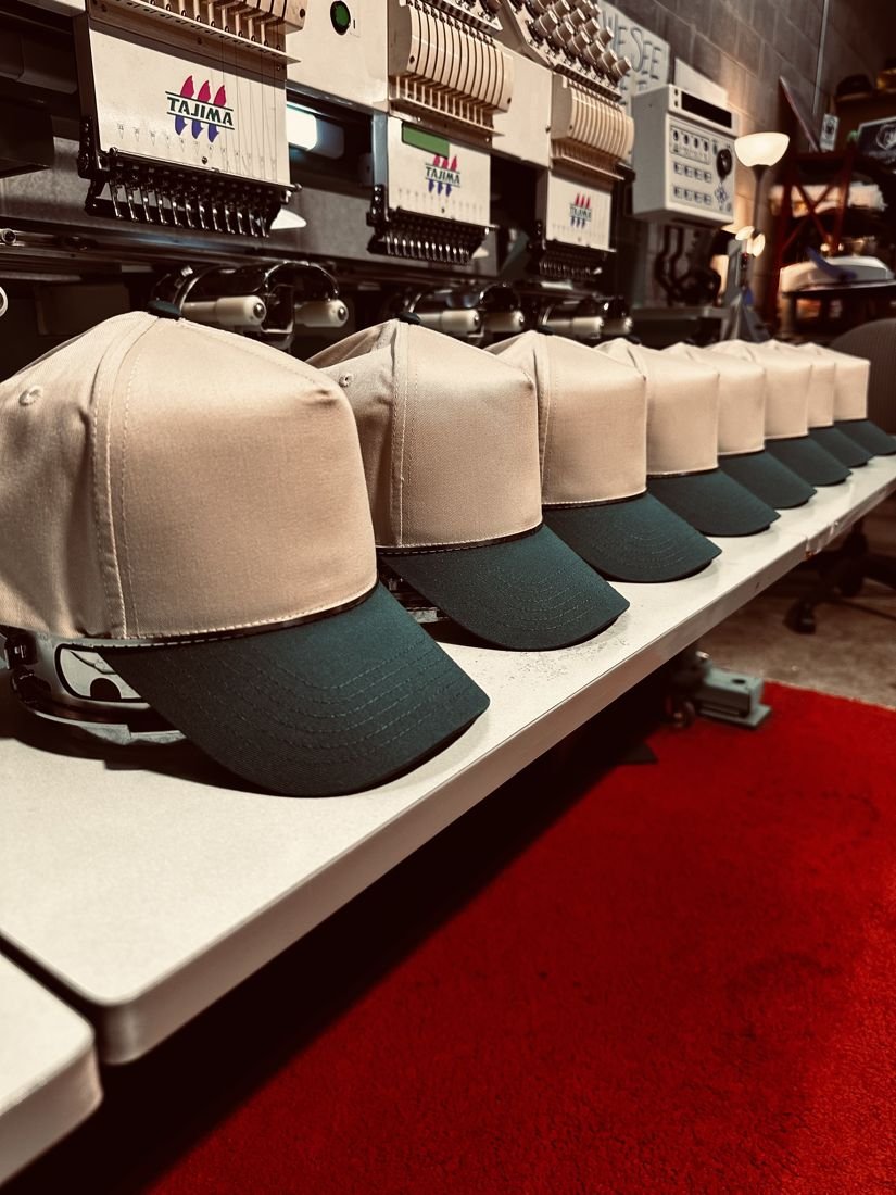 Two-tone hats lined up on the embroidery machines